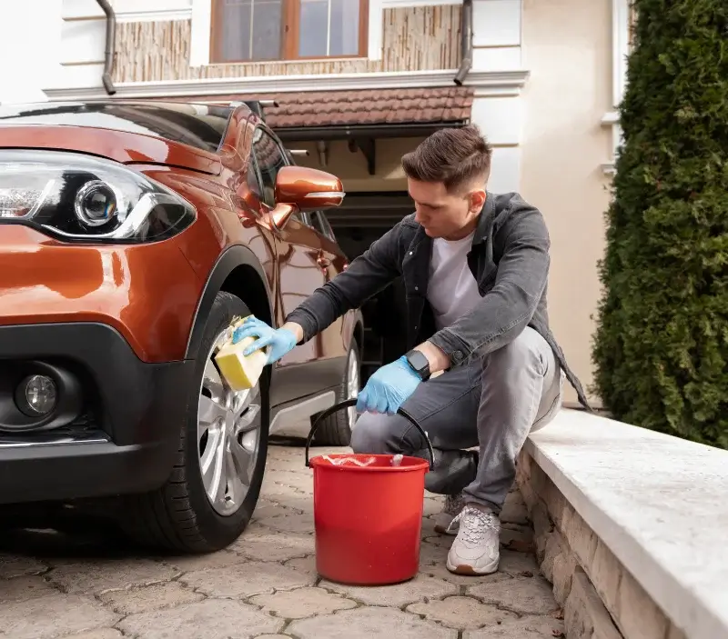 Lavage auto à domicile Le Mesnil-Aubry : professionnel intervenant sur un véhicule